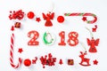 Christmas frame made of red toys and New Year decorations with gingerbread cookies 2018 on white background. Royalty Free Stock Photo