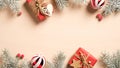 Christmas frame made of vintage red gift boxes, wooden Christmas decorations, pine tree branches, berries on beige background. Royalty Free Stock Photo