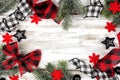 Christmas frame of ornaments, branches and buffalo plaid ribbon on a rustic white wood background Royalty Free Stock Photo