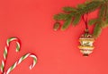 Christmas frame on red background. Green fir branches, Xmas decoration and candy canes. Top view, flat lay. Copy space Royalty Free Stock Photo