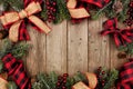 Christmas frame with red and black checked buffalo plaid ribbon, burlap and branches, top view on a wood background