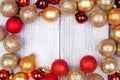 Christmas frame of red and gold ornaments on a winter white wood background Royalty Free Stock Photo