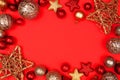 Christmas frame of red and gold ornaments on a red paper background Royalty Free Stock Photo