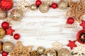 Christmas frame of red and gold ornaments on a white rustic white wood background Royalty Free Stock Photo