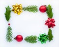 Christmas frame. Red, yellow, green bows on a white background. Leaves of Holly and fir branches. Christmas balls Royalty Free Stock Photo