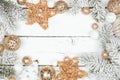 Christmas frame of snowy branches with white and gold ornaments on a white wood background Royalty Free Stock Photo