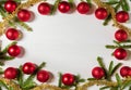 Christmas frame of spruce branches, red balls and gold tinsel. Christmas background on the white wooden desk. Flat lay Royalty Free Stock Photo