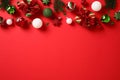 Christmas frame top border made of gift boxes, Xmas decorations, baubles, stars, confetti, for branches on red background. New Royalty Free Stock Photo