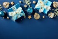 Christmas frame top border made of shiny gift boxes, blue and gold baubles, stars, fir branches on dark blue background. Xmas Royalty Free Stock Photo