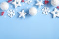 Christmas frame top border of white balls, snowflakes, stars, decorations, red berries on blue background. Xmas, New Year, winter Royalty Free Stock Photo