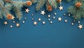 Christmas frame. Top view fir tree branches with cones and wooden handmade stars over blue background. Xmas or New Year banner Royalty Free Stock Photo