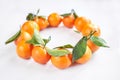 Christmas fruit. Orange fresh tangerines or mandarines with green leaves lie on a white background Royalty Free Stock Photo