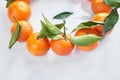 Christmas fruit. Orange fresh tangerines or mandarines with green leaves in a paper bag lie on a white background Royalty Free Stock Photo