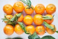 Christmas fruit. Orange fresh tangerines or mandarines with green leaves in a paper bag lie on a white background Royalty Free Stock Photo