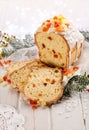 Christmas fruitcake with the addition of mixed candied fruits on a white wooden holiday table.