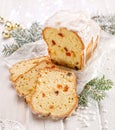 Christmas fruitcake with the addition of mixed candied fruits on a white wooden holiday table.