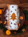 Christmas fruitcake powdered sugar tangerine fir tree festive decoration wooden background flat lay. Stollen cake loaf Royalty Free Stock Photo