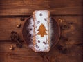 Christmas fruitcake powdered sugar tangerine fir tree festive decoration wooden background flat lay. Stollen cake loaf