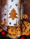 Christmas fruitcake powdered sugar tangerine fir tree festive decoration wooden background flat lay. Stollen cake loaf