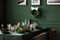 Christmas garland and black and white posters on green wall of dining room set for christmas dinner