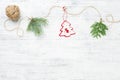 Christmas garland of conifer branches & red christmas tree against white wooden background. Royalty Free Stock Photo