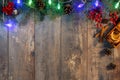 Christmas garland lights and decoration on wooden background. Christmas fir tree with decoration on dark wooden board. Border art Royalty Free Stock Photo