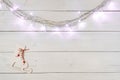 Christmas garland lights and wooden skates toy on white wooden boards background