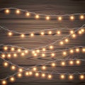 Christmas garlands isolated on wooden background. Xmas realistic overlay golden lights card. Holidays decorations bright Royalty Free Stock Photo