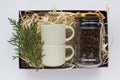 Christmas gift basket with coffee beans in glass jar and two espresso coffee cups. Corporate holiday gift box ideas.