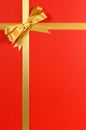 Christmas gift border frame with gold ribbon and bow red background paper vertical Royalty Free Stock Photo