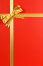 Christmas gift border gold ribbon bow red background vertical Royalty Free Stock Photo