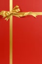 Christmas gift border gold ribbon bow red background vertical Royalty Free Stock Photo