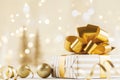 Christmas gift box against golden bokeh background. Holiday greeting card. Royalty Free Stock Photo