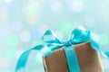 Christmas gift box against turquoise bokeh background. Holiday greeting card. Royalty Free Stock Photo