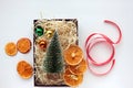 Christmas gift box with christmas decorations, balls, dried orange slices and red ribbon on white background. Royalty Free Stock Photo