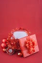 Christmas gift box with decorations and color ball on red background Royalty Free Stock Photo