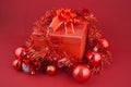 Christmas gift box with decorations and color ball on red background Royalty Free Stock Photo