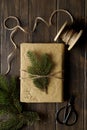 Christmas gift box with fir branches decorations on wooden background. Top view Royalty Free Stock Photo