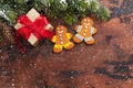 Christmas gift box, gingerbread cookies and fir tree branch covered by snow on wooden background. Top view xmas backdrop with Royalty Free Stock Photo