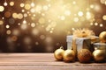 Christmas gift box with gold ribbon bow and golden Christmas ball decoration on wooden table. Merry Christmas present with bokeh Royalty Free Stock Photo