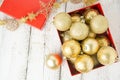 Christmas Gift Box with golden baubles and Decorations. White rustic wooden table Royalty Free Stock Photo