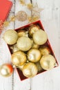 Christmas Gift Box with golden baubles and Decorations. White rustic wooden table Royalty Free Stock Photo