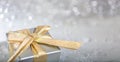 Christmas gift box with golden ribbon on abstract bokeh lights and glitter background Royalty Free Stock Photo