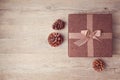 Christmas gift box with pine corn on wooden background. View from above