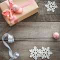 Christmas gift box with pink ribbon and ball, decor from snowflakes, silver ribbon and decor around. Royalty Free Stock Photo