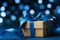 Christmas gift box or present against blue bokeh background. Holiday greeting card. Royalty Free Stock Photo