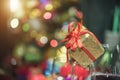 Christmas gift box or present with red bow ribbon on light bokeh blurred background. Copy space for greeting text. Cerebrate part Royalty Free Stock Photo