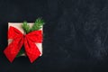 Christmas gift box. Christmas present box with red  bow and tree branch on dark stone background Royalty Free Stock Photo