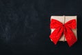 Christmas gift box. Christmas present box with red ribbon bow on dark stone background Royalty Free Stock Photo