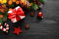 Christmas gift box with red bow and decorations on black wooden background Royalty Free Stock Photo